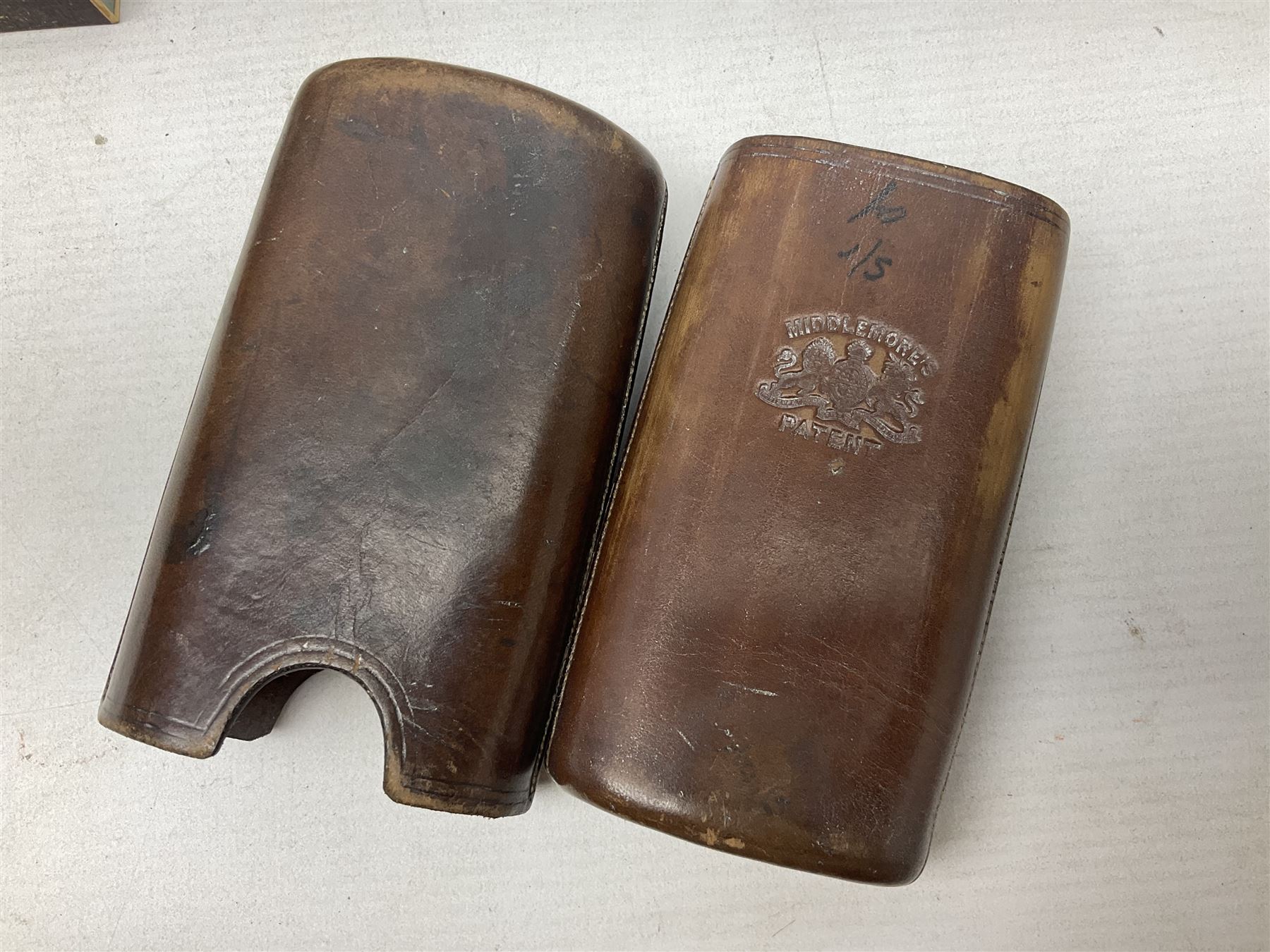 Victorian leather cigar protector with metal match striking plate on the end and internal spring to hold the cigars in place; expands for differing lengths of cigar, minimum L12.5cm; another similar leather cigar case marked Middlemore's Patent with attached vesta case and striker; three Bryant & Mays tin-late matchbox holders including 1935 Jubilee; and small box of matches (6)