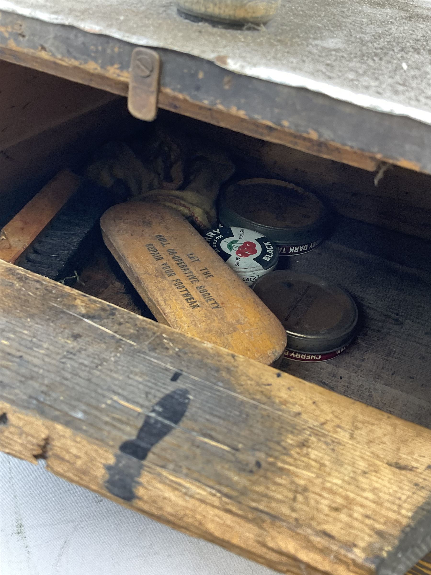 Cherry Blossom Shoe Polish shoe shine box, of sloping form, with three pictorial enamel panels advertising dark tan, black and light tan polishes, the reverse with a hinged compartment, the top mounted with a handle and foot rest in the form of a shoe sole, H29cm W42cm D33cm