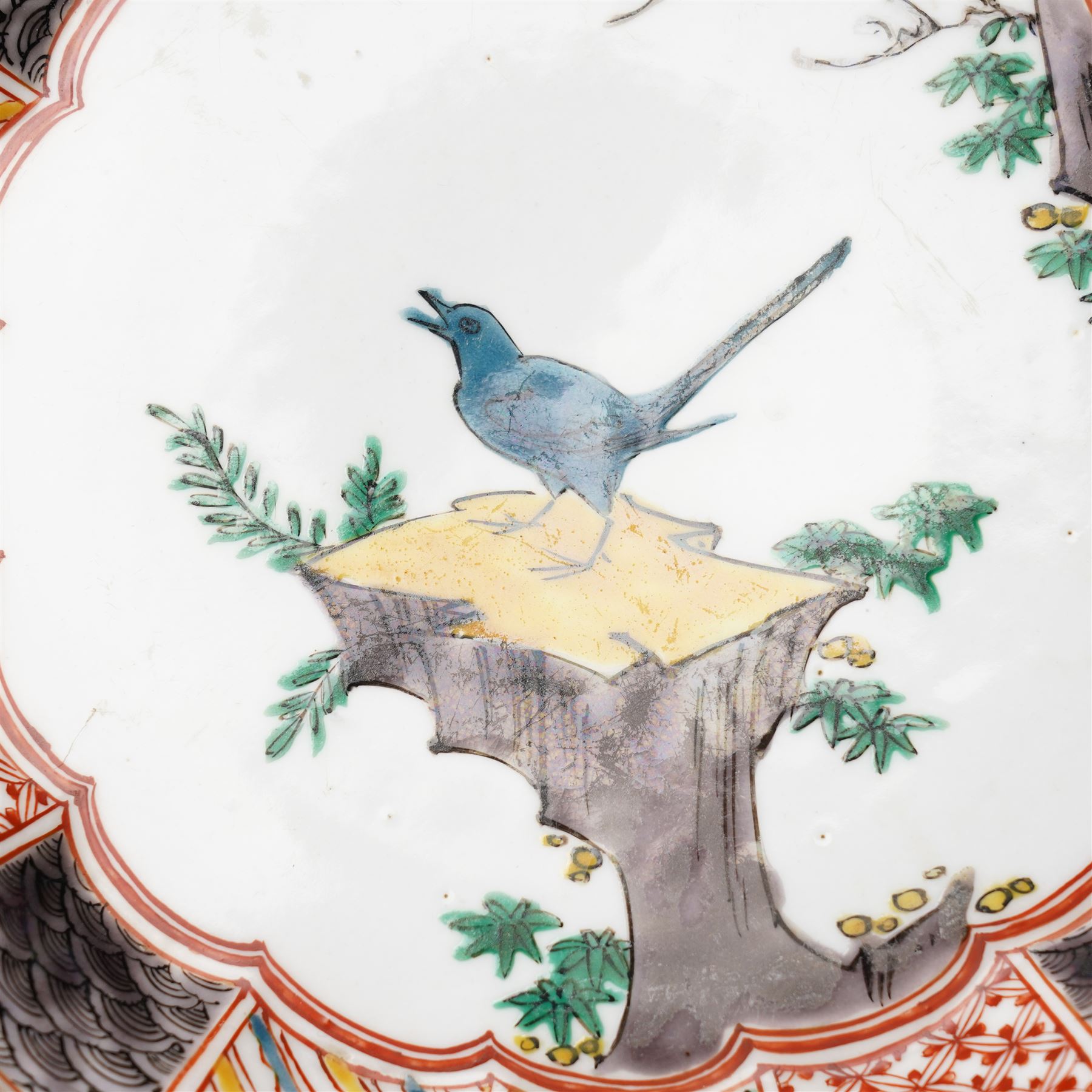 Pair of Japanese Edo period Ko Kutani dishes, decorated in green, yellow, blue iron-red, and aubergine enamels, the centres painted with a singing bird perched on a rock among foliage, within a border of alternating geometric designs and a chocolate-brown rim, the reverse with underglaze blue foliage, Fuku mark, D20.8cm (2) A matching pair of dishes is held in the collection of the Cleveland Museum of Art (see accession no. 1964.262)