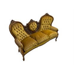Victorian style stained beech double ended settee, the cresting rail carved with leaf motifs, pierced and carved back decorated with scrolling foliage ans fruit, in buttoned upholstery, moulded cabriole supports