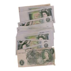 Approximately thirty-two Queen Elizabeth II one pound notes, and an Isle of Man fifty pence note