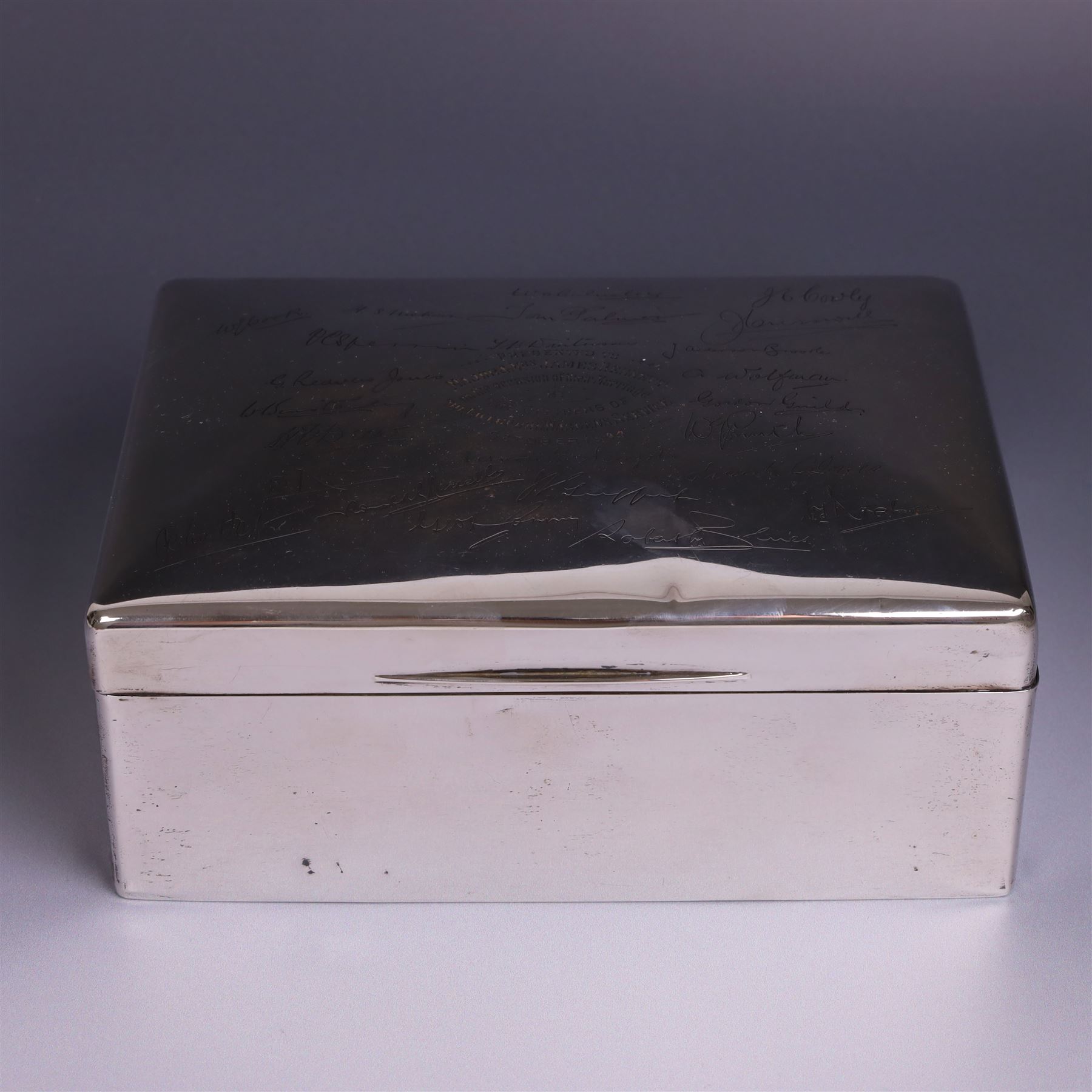 WWII silver mounted cigarette box, of rectangular form, the hinged cover inscribed 'presented to Major & Mrs James Bennett on the occasion of their marriage by the officers of the Liverpool Wardens Service October 1944' and engraved with twenty-four signatures of the officers, with softwood interior, hallmarks worn and indistinct, H7.5cm, W19cm