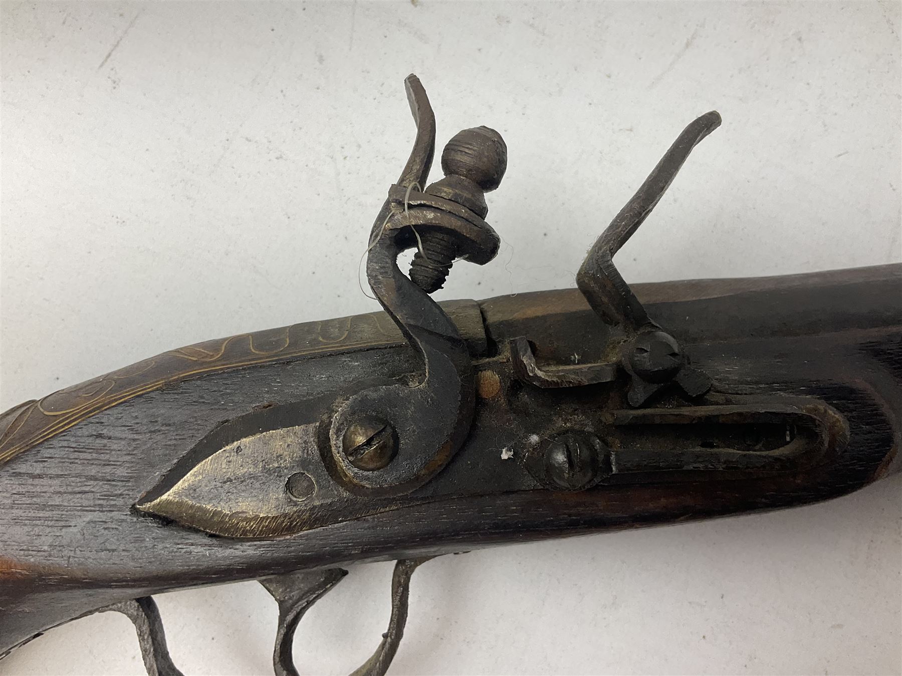 Reproduction flintlock pistol, the full walnut stock with brass filigree inlay and mounts and skull crusher butt L46cm; no visible proof marks FIREARMS CERTIFICATE REQUIRED OR RFD