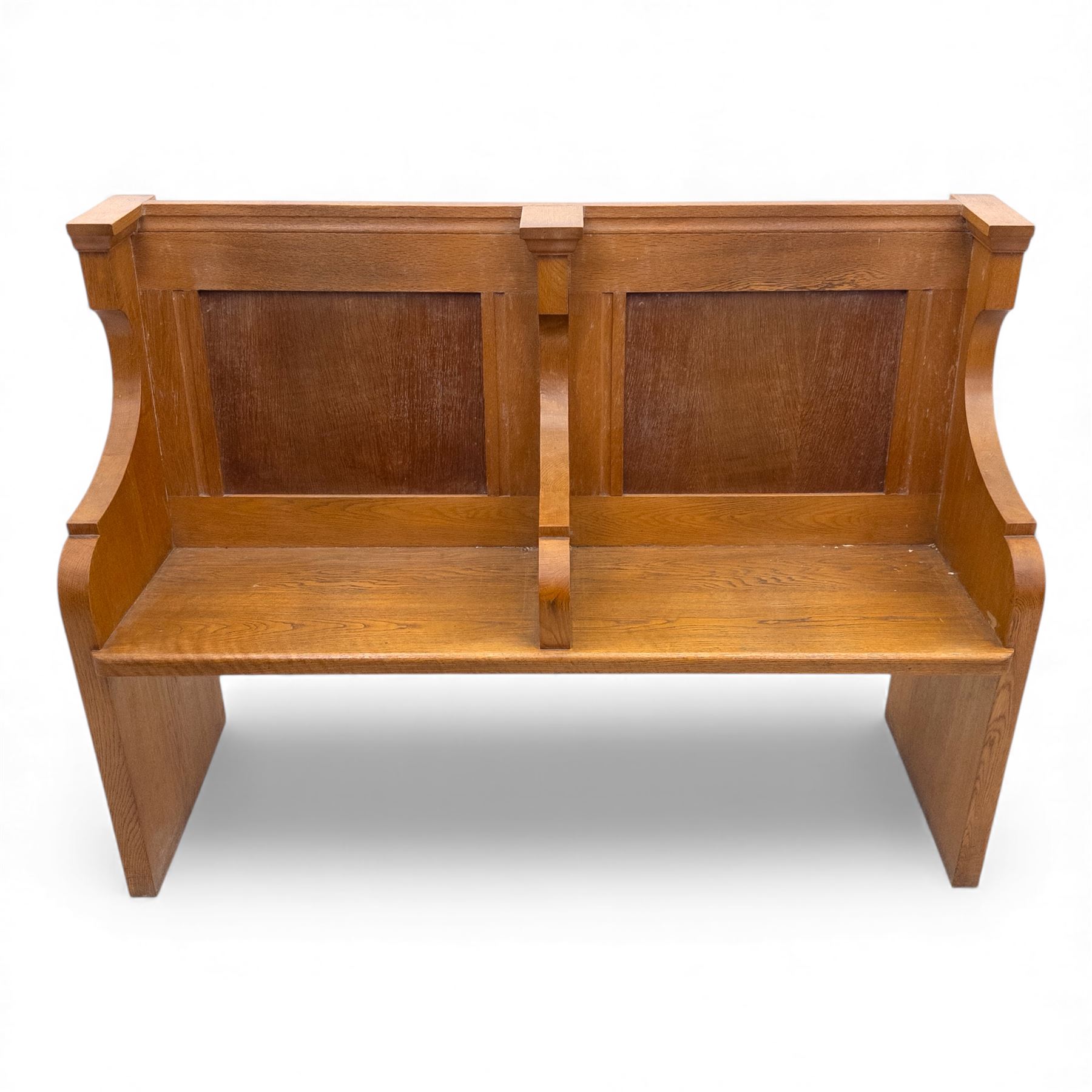 Pair of mid 20th century oak ecclesiastical pews, each with panelled backrests and shaped end supports, of solid construction and mellow honeyed tone