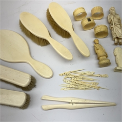 A selection of assorted ivory and bone items, to include a Japanese okimono modelled as a sage, four napkin rings, three with hallmarked silver cartouches, a early 20th century dressing table set, comprising hand held mirror, two hair brushes, two clothes brushes, and glove stretchers, plus a number of picks with carved figural terminals. 