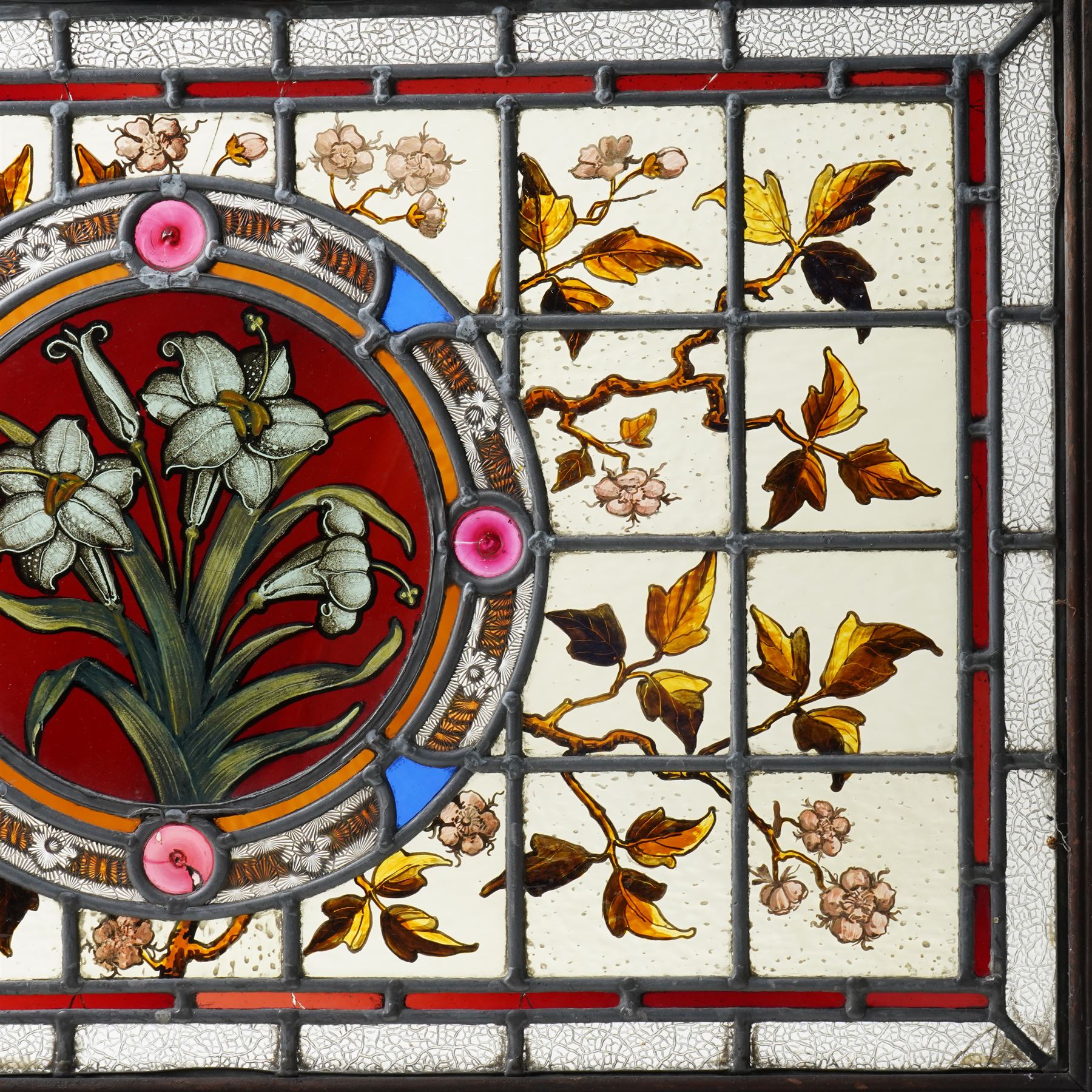 Victorian Aesthetic movement stained glass leadlight window panel, the central panel hand painted with a sprig of daffodils, the surrounding panels profusely decorated with branches and leaves, overall 62cm x 84cm 