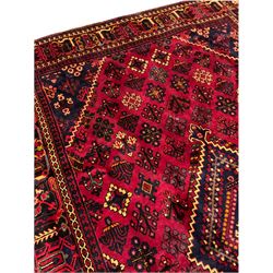 Persian red ground rug, with central stepped lozenge surrounded by plant motifs, the border decorated with a series of stylised motifs with guard bands 
