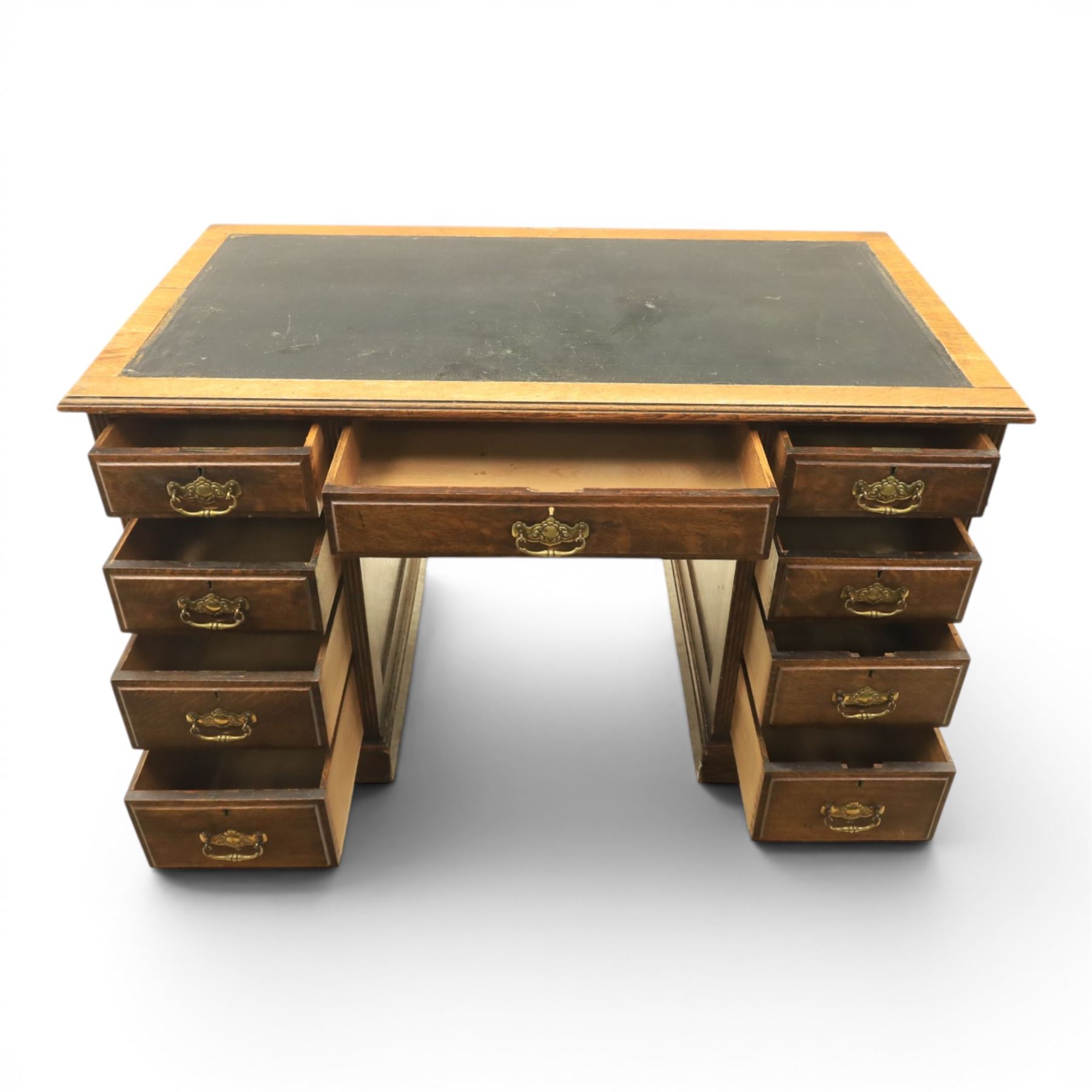 Oak twin pedestal desk with leather top, moulded rectangular top with inset black leather writing surface, nine fielded panelled drawers with brass handles, raised on a plinth base with castors