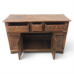 George III oak dresser base, rectangular top with moulded edge, three fielded panelled drawers with brass swan neck handles, over four fielded panelled front with the central two cupboard doors, raised on stile supports