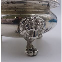 1930's silver mustard pot and cover, of squat bellied form with oblique gadrooned rim and capped scroll handle, the slightly domed cover lifting to reveal a blue glass liner, upon three lion mask mounted paw feet, hallmarked Ellis & Co, London 1935, H6.5cm, approximate weight excluding liner 5.33 ozt (166.1 grams)