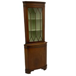 20th century mahogany corner display cabinet,  projecting cornice, dentil frieze, single glazed door enclosing two shelves, above single cupboard door , shaped bracket supports