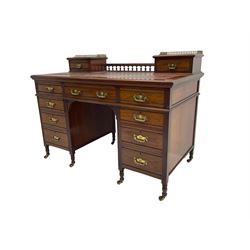 Maple & Co - Edwardian mahogany twin pedestal desk, the raised back with spindle gallery and open shelf to centre flanked by two trinket drawers, rectangular top with inset writing surface, fitted with one long and eight short graduating drawers flanked by fluted uprights, raised on brass and ceramic castors, stamped to central drawer