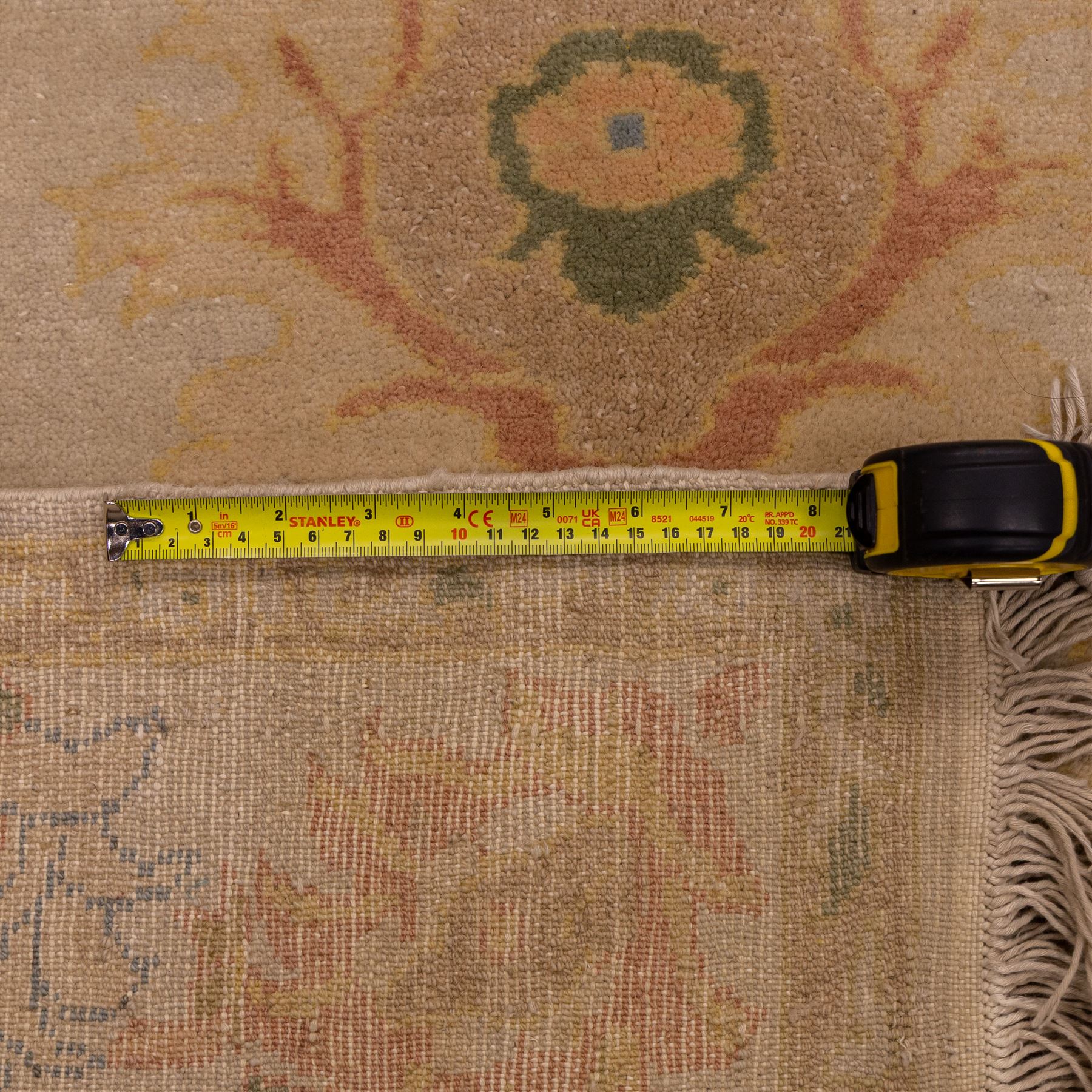 West Persian hand-knotted Ziegler design rug, ivory field decorated with an all-over lattice of stylized palmettes and floral sprays linked by angular vines, border of scrolling floral ornamentation in a palette of blush pink, sage green, powder blue, and soft ochre, with cotton fringe ends 