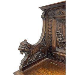 19th century heavily carved oak settle, the moulded upper rail over triangular foliage carved frieze, three Flemish style carved panels depicting tavern scenes, acanthus carved uprights terminating to lion carved arms, hinged box seat, the panelled front carved with lion masks and extending scrolled acanthus leaves, on moulded skirt base