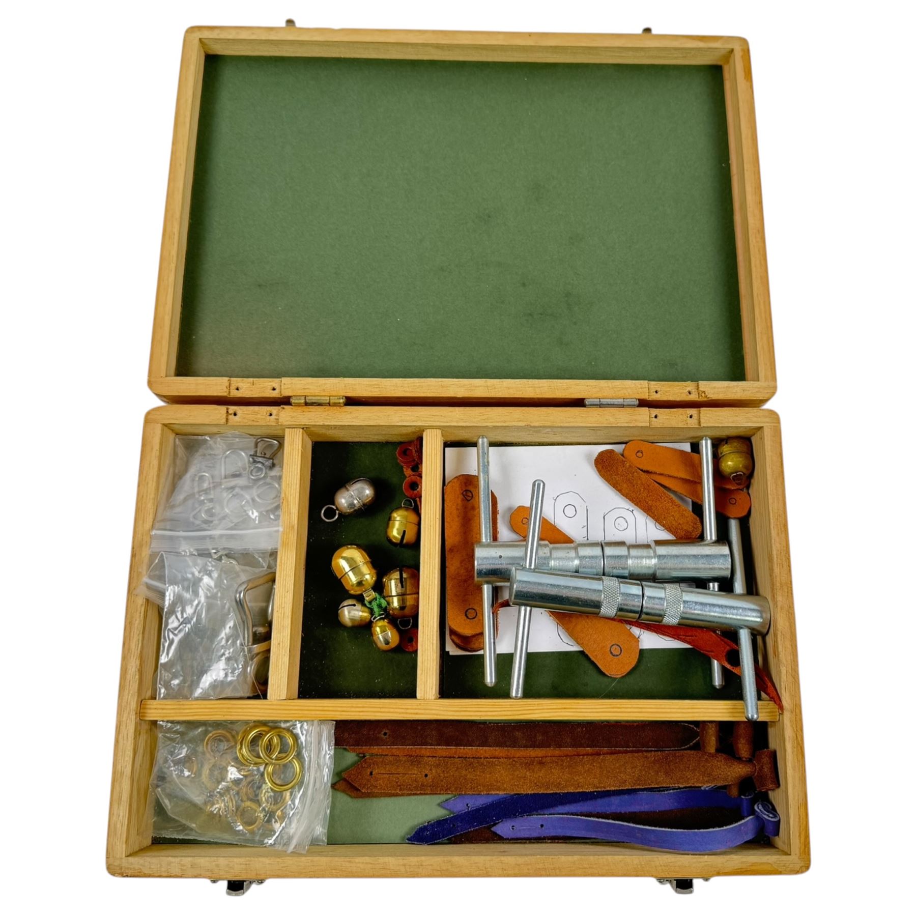 Falconry equipment, including two eyelet tools, various swivels, jessies, bells etc, within a wooden box  