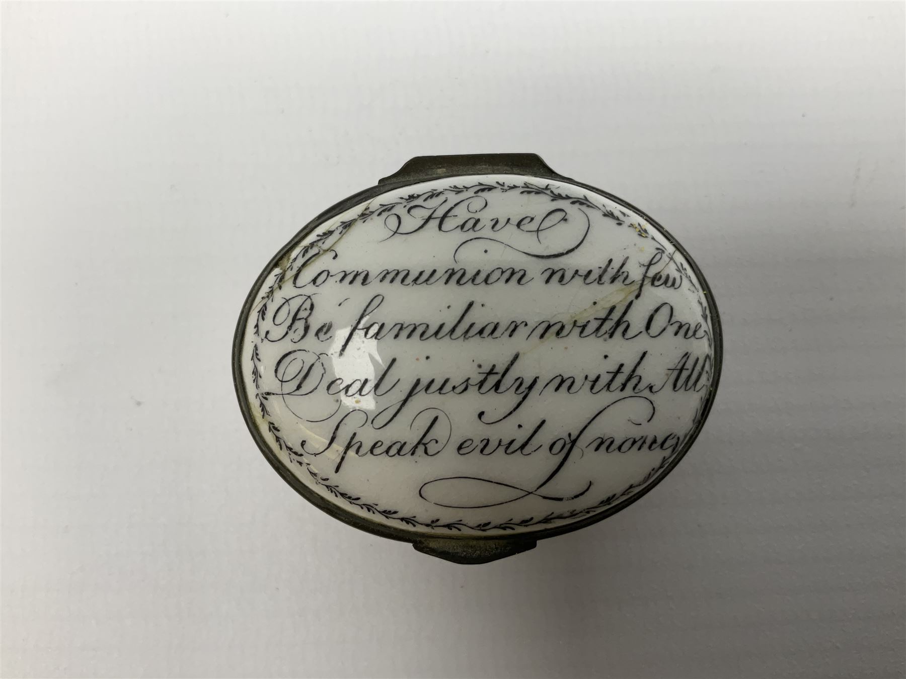Late 18th century Staffordshire enamel patch box, of oval form with pink base, the hinged cover inscribed 'Have Communion with few, Be familiar with One, Deal justly with All, Speak evil of none' upon a white ground, opening to reveal mirror beneath, W4cm