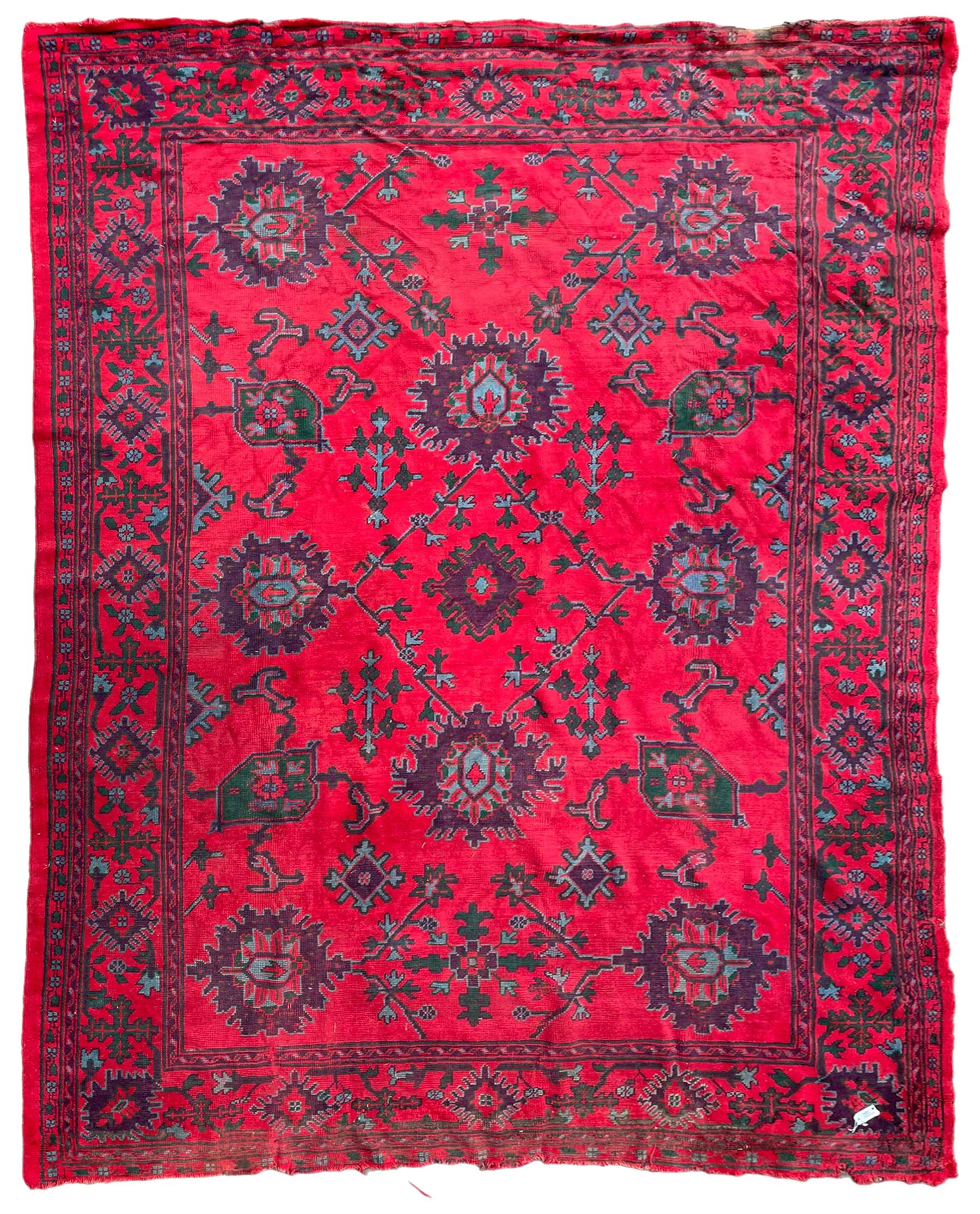 Early 20th century Western Anatolia Turkish Oushak crimson ground carpet, decorated with large Palmettes with trailing branches, the main border decorated with repeating stylised motifs within guard stripes 