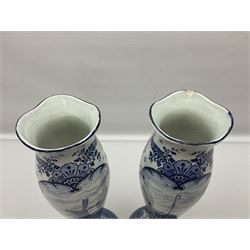 Pair of Delft blue and white vases, of elongated baluster form with shaped fluted rim, one depicting a Dutch sailing scene, the other a Dutch windmill scene, with painted mark beneath, H35.5cm