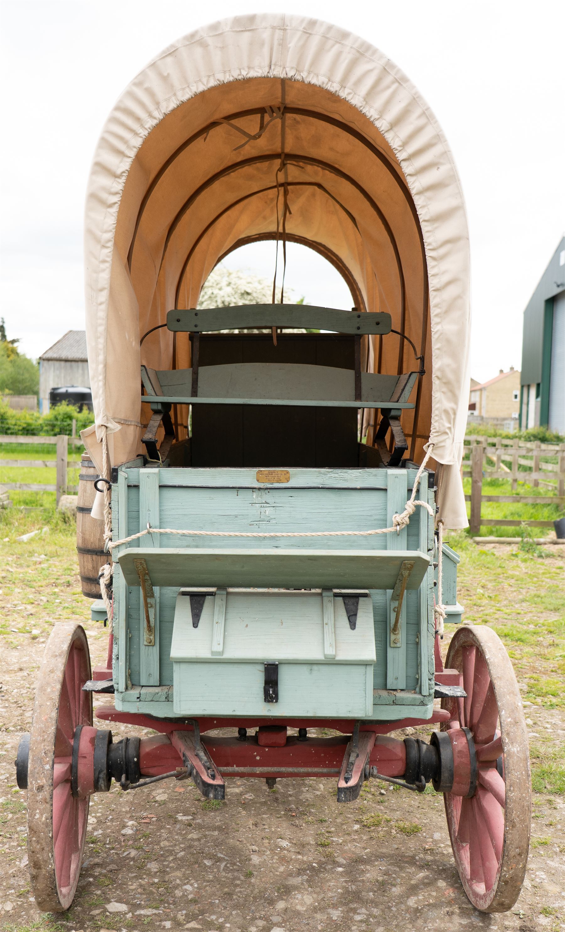 Western Covered Chuck Wagon

A large four wheeled covered wagon of timber construction, painted pale green with red painted wooden spoked wheels and a cream canvas tilt over an arched frame. The wagon has a traditional box body with covered rear compartment, front driving position, underbody turntable steering and iron fittings throughout. Fitted with external equipment details including a side mounted barrel, lidded storage chest, rope tie downs, horseshoe fittings and rear storage box.

Features

• Pale green painted timber body
• Cream canvas tilt over arched frame
• Covered rear compartment
• Front driving position
• Side mounted barrel
• External lidded storage chest
• Rear storage box
• Wooden spoked wheels
• Iron tyres
• Underbody turntable steering
• Rope tie downs
• Horseshoe fittings
• Iron hardware and brackets
• Brass restoration plaque to rear

Dimensions:
Overall length: 335 cm
Width: 170 cm
Height: 275 cm

Wheel Diameters:
Front wheels: 92 cm
Rear wheels: 112 cm

Seating:
Driver: 1
Passenger: Rear covered compartment