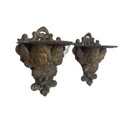 Pair cast iron wall mounted garden pot brackets in the form of putti, decorated with foliage and scrolls