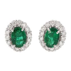 Pair of white gold oval cut emerald and round brilliant cut diamond cluster stud earrings, stamped 18K, total diamond weight approx  0.70 carat, total emerald weight approx 1.45 carat
