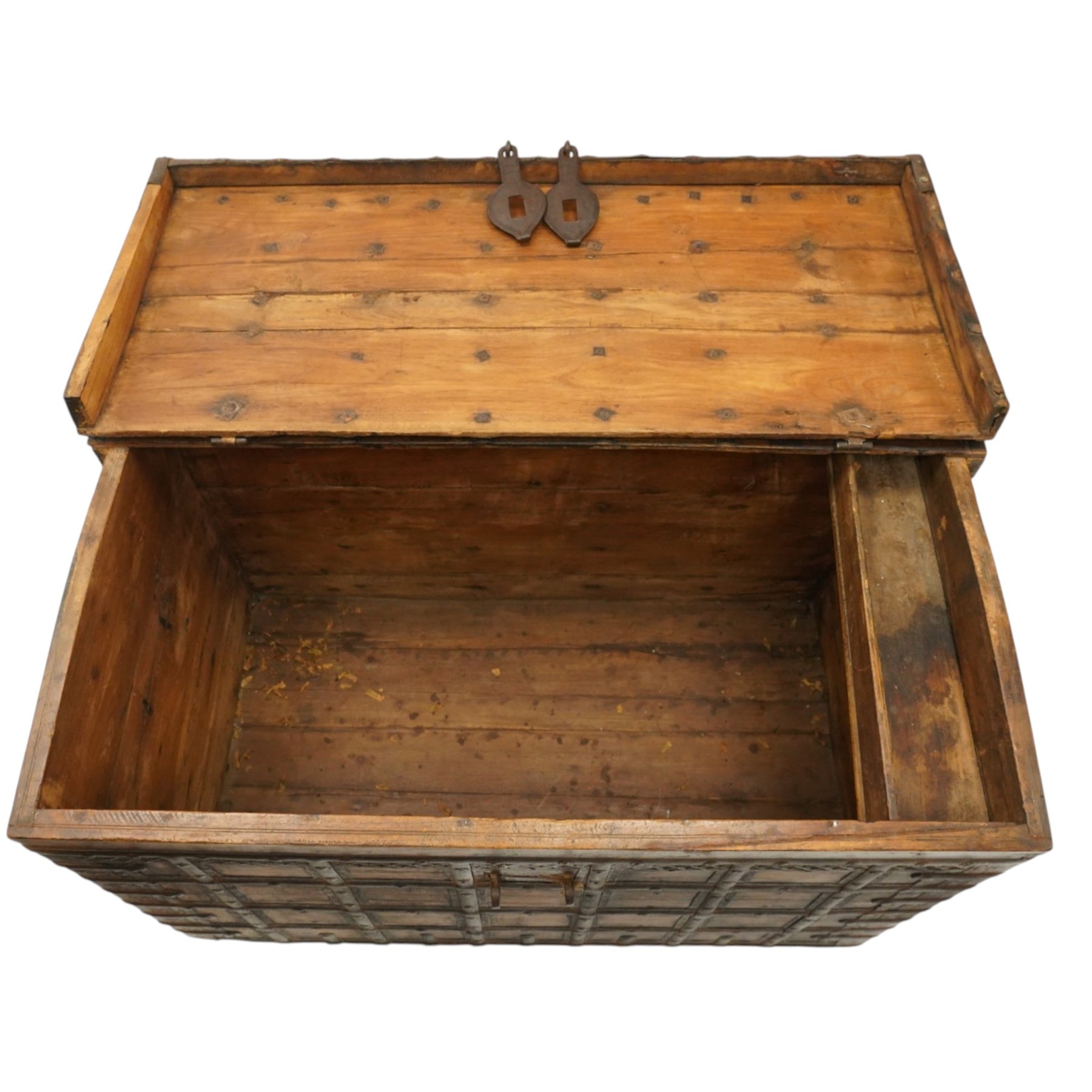 Large 19th century North Indian teak and wrought iron-bound dowry chest, probably Rajasthani, the shallow domed plank lid secured with broad iron straps above a lattice-carved frieze and grid of riveted iron bands, with twin shaped hasps, side carrying handles and fitted interior till, on bracket feet