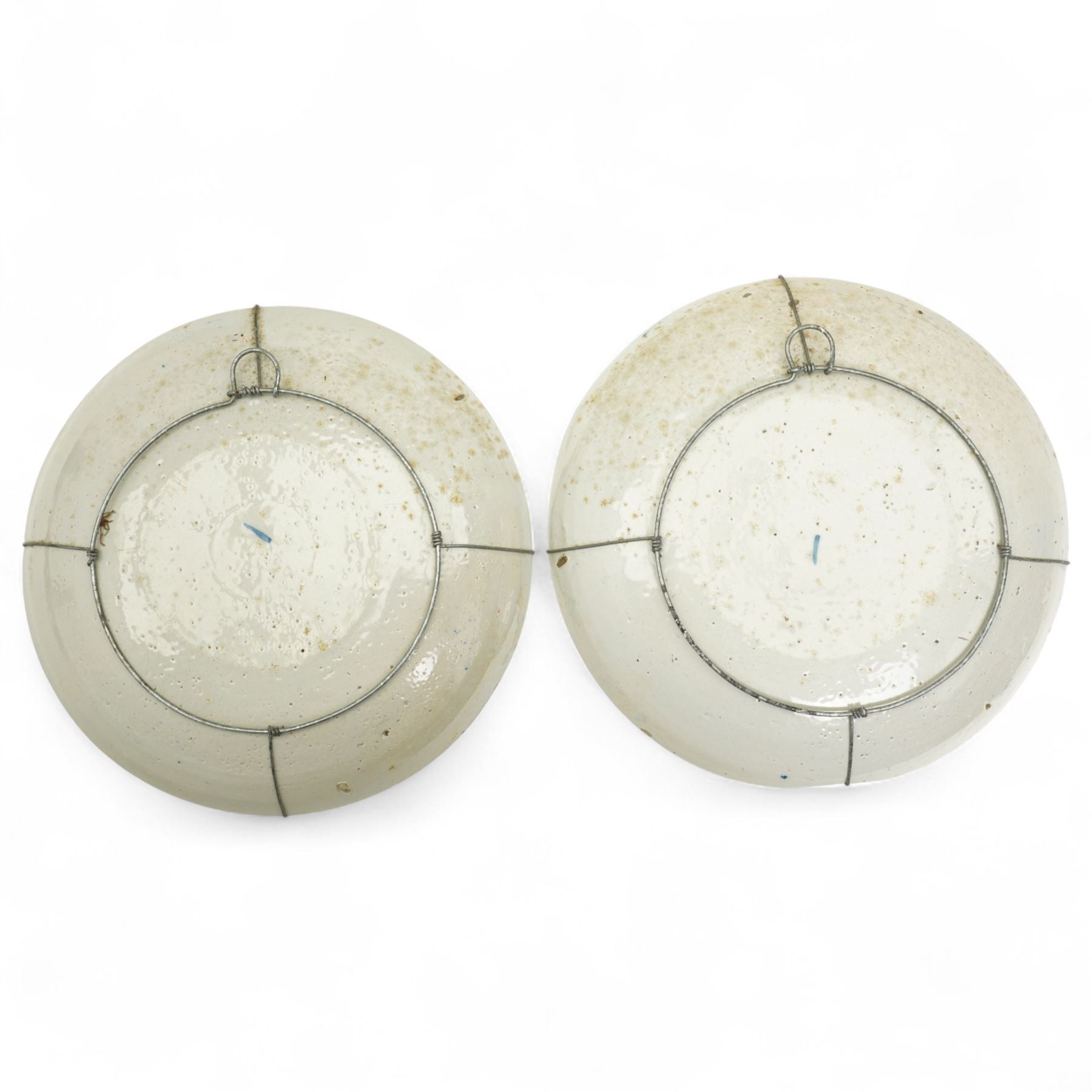 Pair of 18th century English Delft tin glazed plates, of circular form, decorated with stylised flowers in red and yellow, within a border of traditional repeating patterns of foliage and cross-hatching, bearing blue marks to base, D23cm