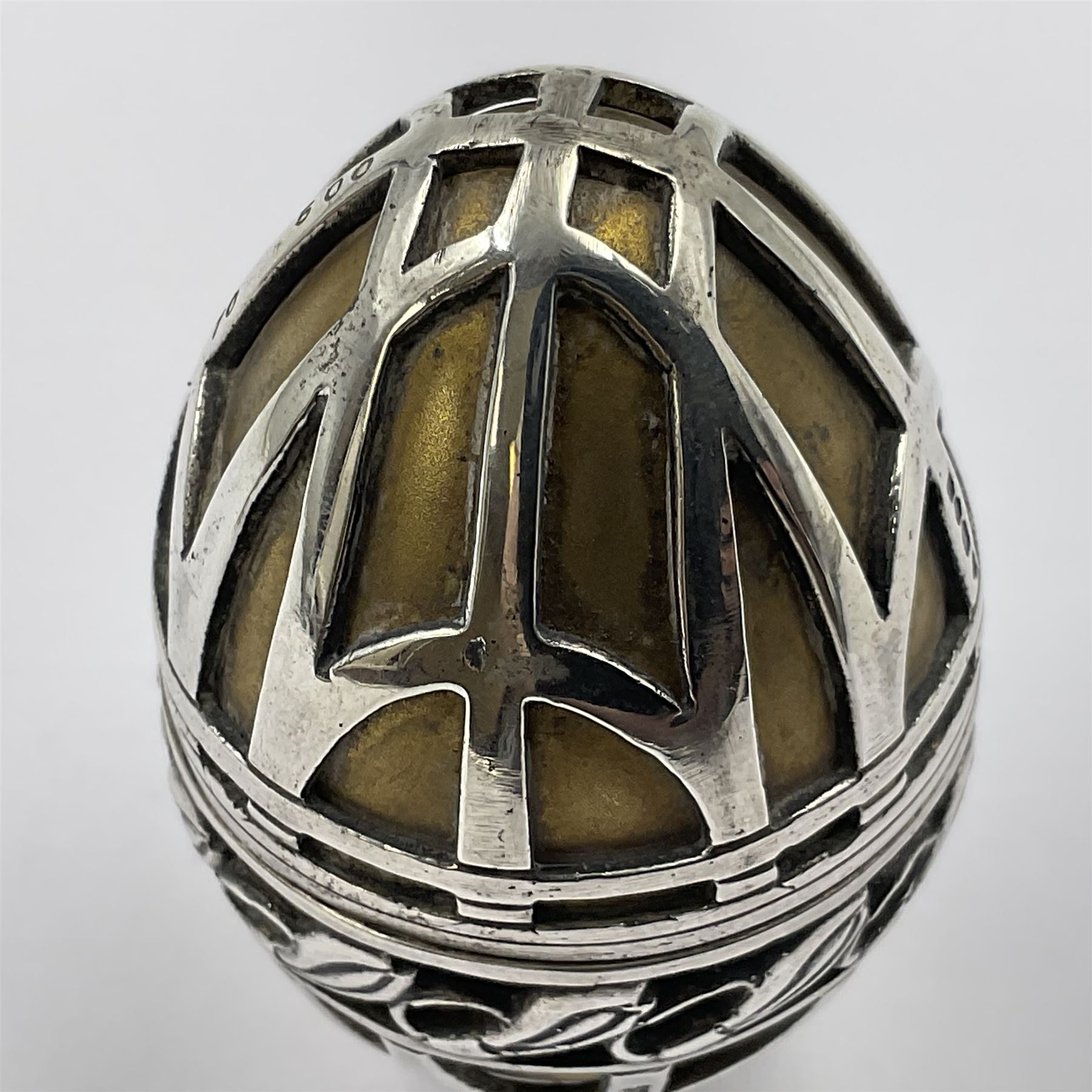Modern silver limited edition Easter egg, no. 70/500, the gilded body decorated in relief with silver latticework and a band of flower heads, the detachable cover opening to reveal a gilt interior, each hallmarked St James House Company, London 1978, H5.5cm