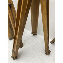 Three wooden adjustable tripods for plate cameras, together with a Linhof of Munchen metal tripod in a canvas case 