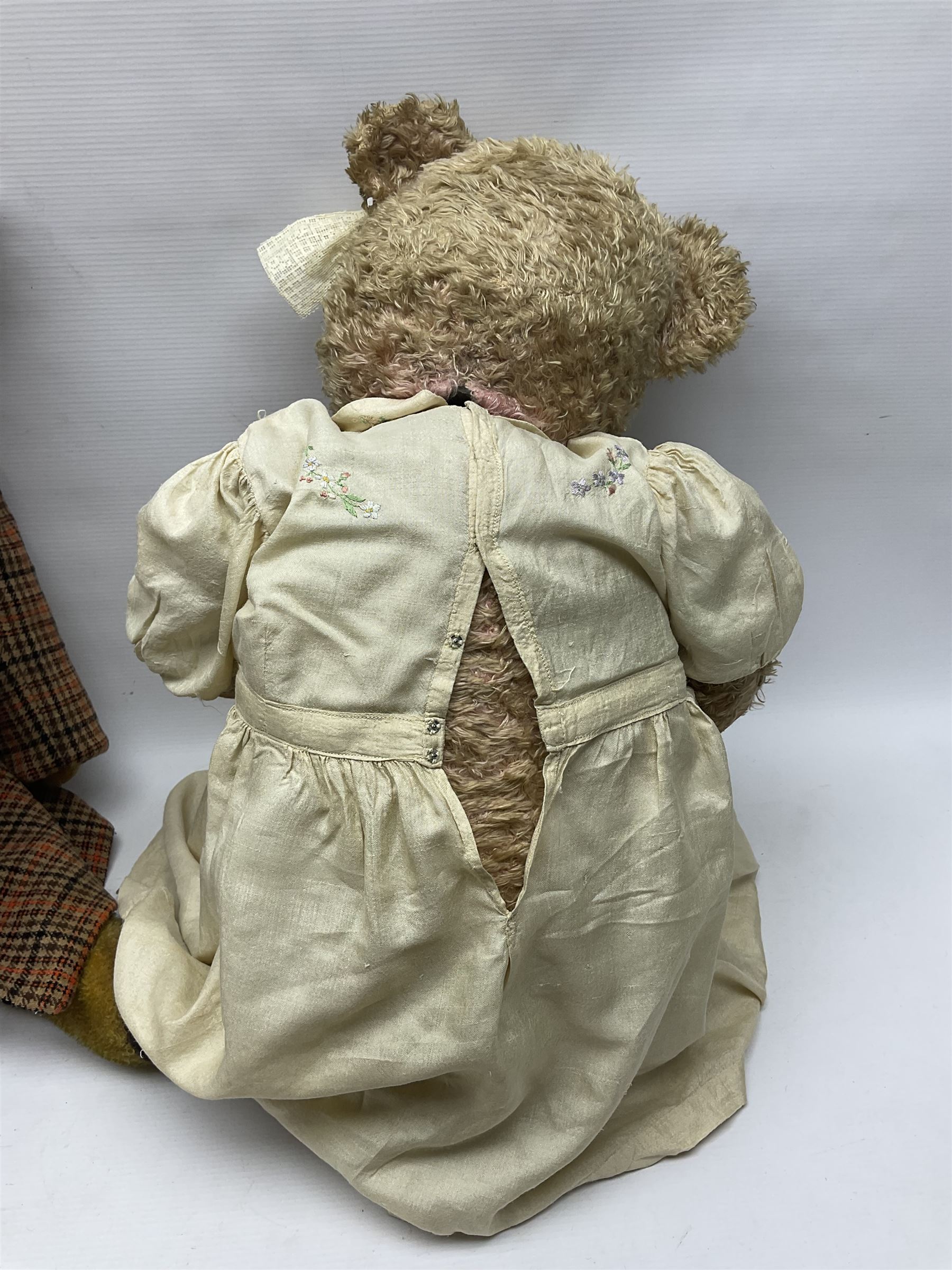 Two early 20th century straw filled jointed teddy bears, first example wearing a tweed jacket bearing Geoffrey Saville label, with leather padded paws and ears, horizontally stitched nose and humpback; second example with applied eyes, vertically stitched nose and faux leather paw pads, both with growler mechanisms, tallest H74cm 