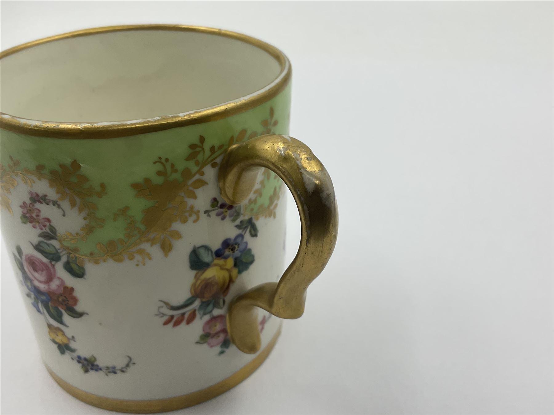 Sèvres soft paste porcelain coffee can and saucer with date code for 1754, painted and gilded with flowers, dangling from the shaped green border, interlaced LL monogram enclosing the date letter A above painters mark for Dodin, coffee can H7cm, saucer D14.5cm