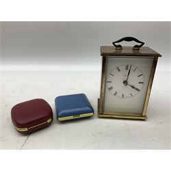 Two travelling alarm clocks with leather effect cases to include a Europa example, together with a Metamec battery operated clock