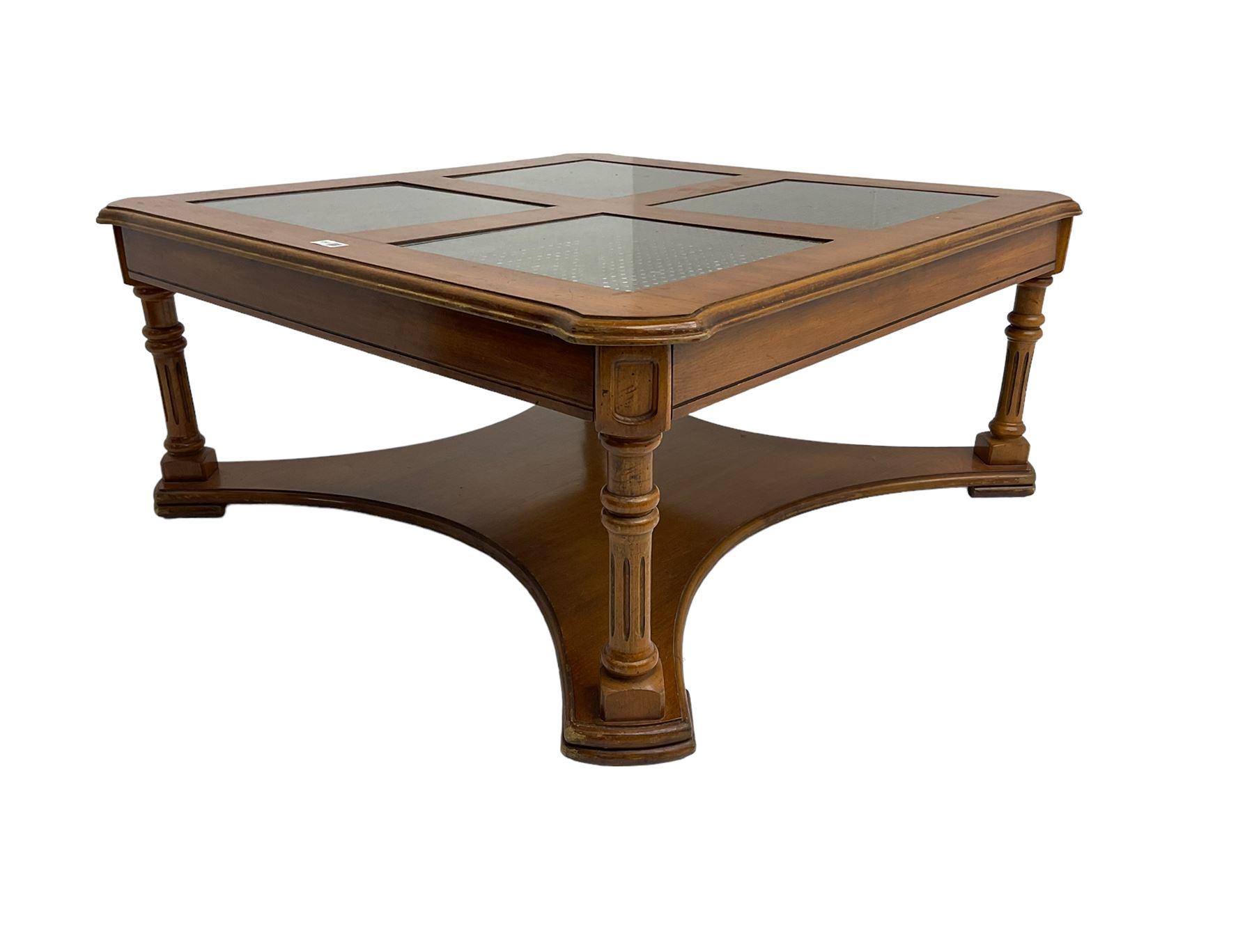 Coffee table, square top with cane work insets, raised on four fluted column supports joined by shaped base