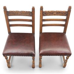 Craftsman made set of four solid oak dining chairs with leather seats, with carved cresting rail, on red leather seats with studded trim, raised on block and turn supports united by H-stretcher