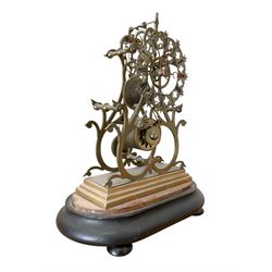English-Late 19th century 8-day Skeleton clock on an oval ebonised base c1880, with pierced brass plates and silvered chapter ring, Roman numerals and gothic trefoil hands, chain driven five-pillar fusee movement and pierced mainspring barrel cap, timepiece movement with key and pendulum. 