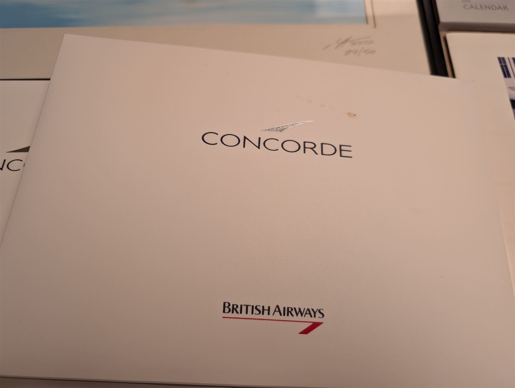 Collection of Concorde memorabilia, including paperweight, limited edition print, calendars, scale model, etc 