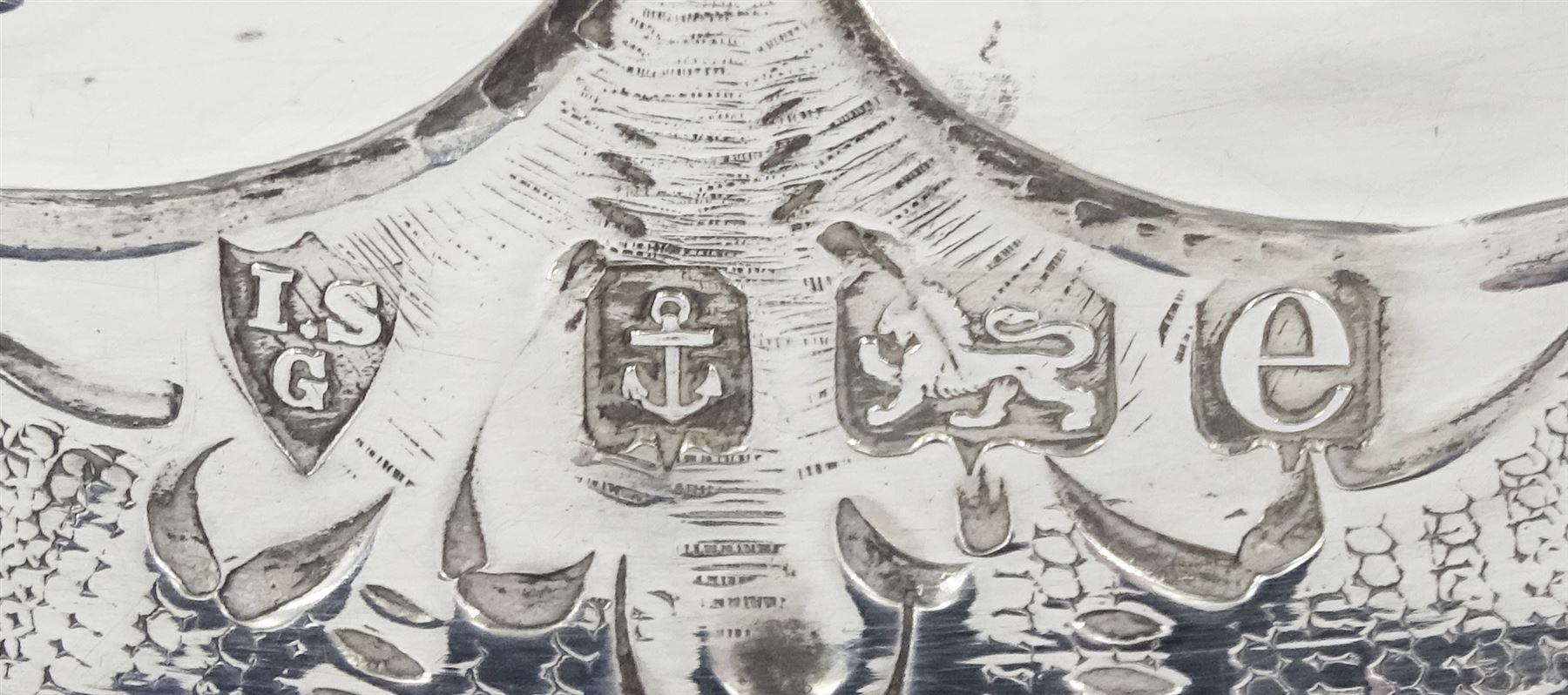 Edwardian silver dish ring in the Irish manner, of circular waisted form, embossed and pierced throughout with flower heads and foliate and C scrolls, hallmarked I S Greenberg & Co, Birmingham 1904, with accompanying blue glass liner, upper rim D17.5cm, approximate weight 6.84 ozt (213 grams)