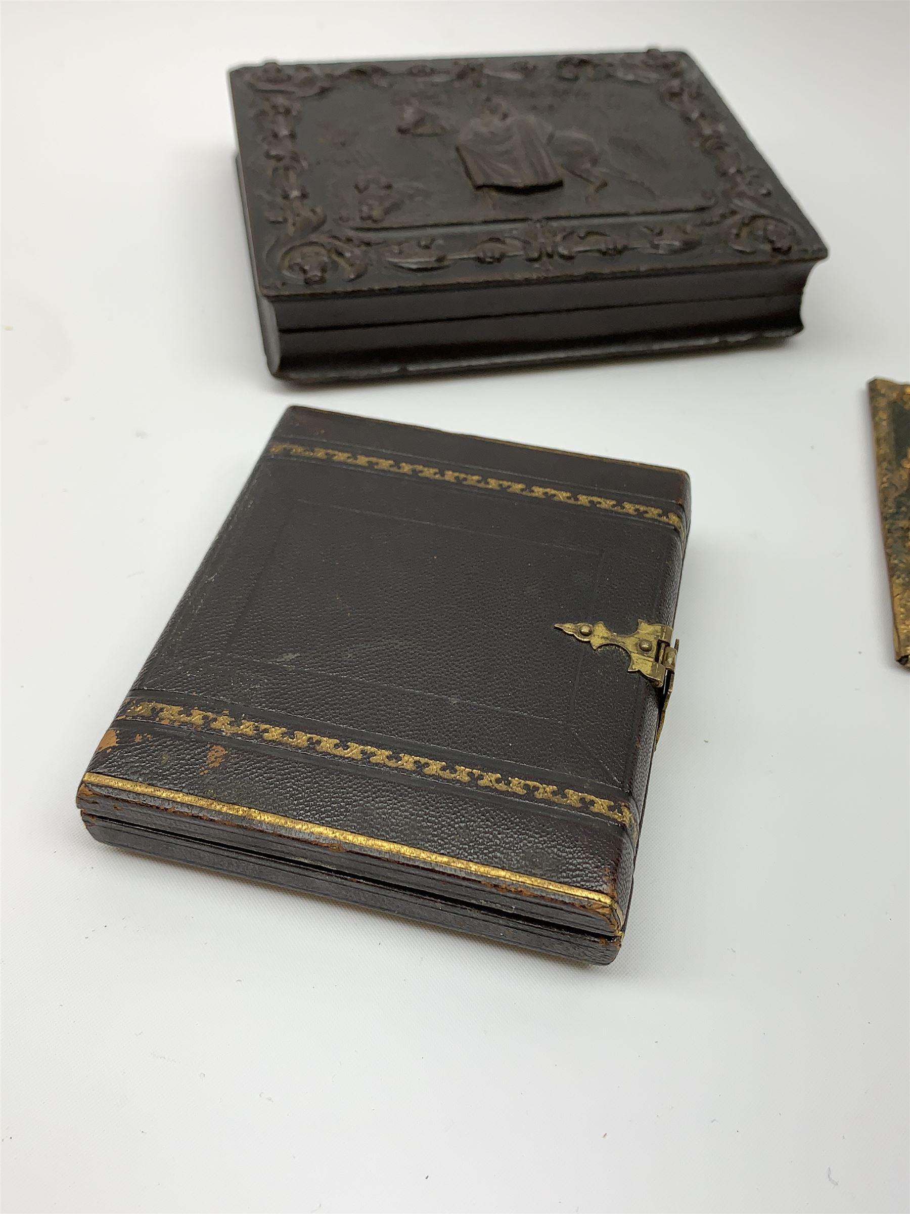 A Victorian ambrotype photograph in gilt surround and Vulcanite type Union case, decorated in low relief to front and verso with a female figure upon horseback, H12.5cm, together with a leather case daguerreotype, and a further loose example. (3).  