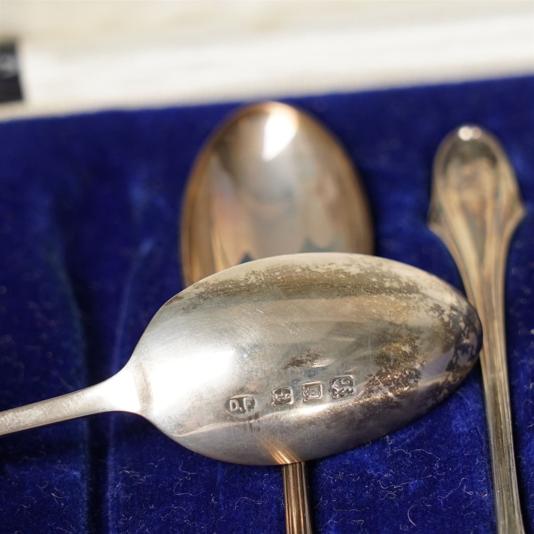 Set of six silver coffee spoons with shaped terminals, cased London 1924, another set of similar spoons London 1924 cased and a set of six silver bead knop spoons Birmingham 1936, cased