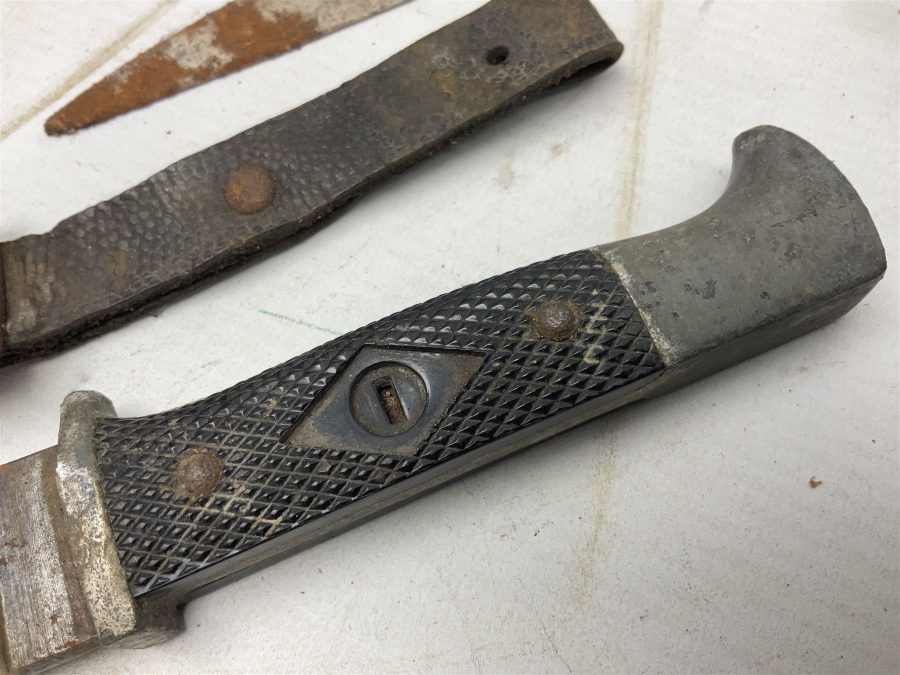 Indian kukri with 29cm curving steel blade and nickel mounted horn grip; in leather covered scabbard with one skinning knife L42cm overall; Hitler Youth knife with scabbard in relic condition; and three African graduated knives each with crudely carved wooden grips and painted leather covered scabbards (5)