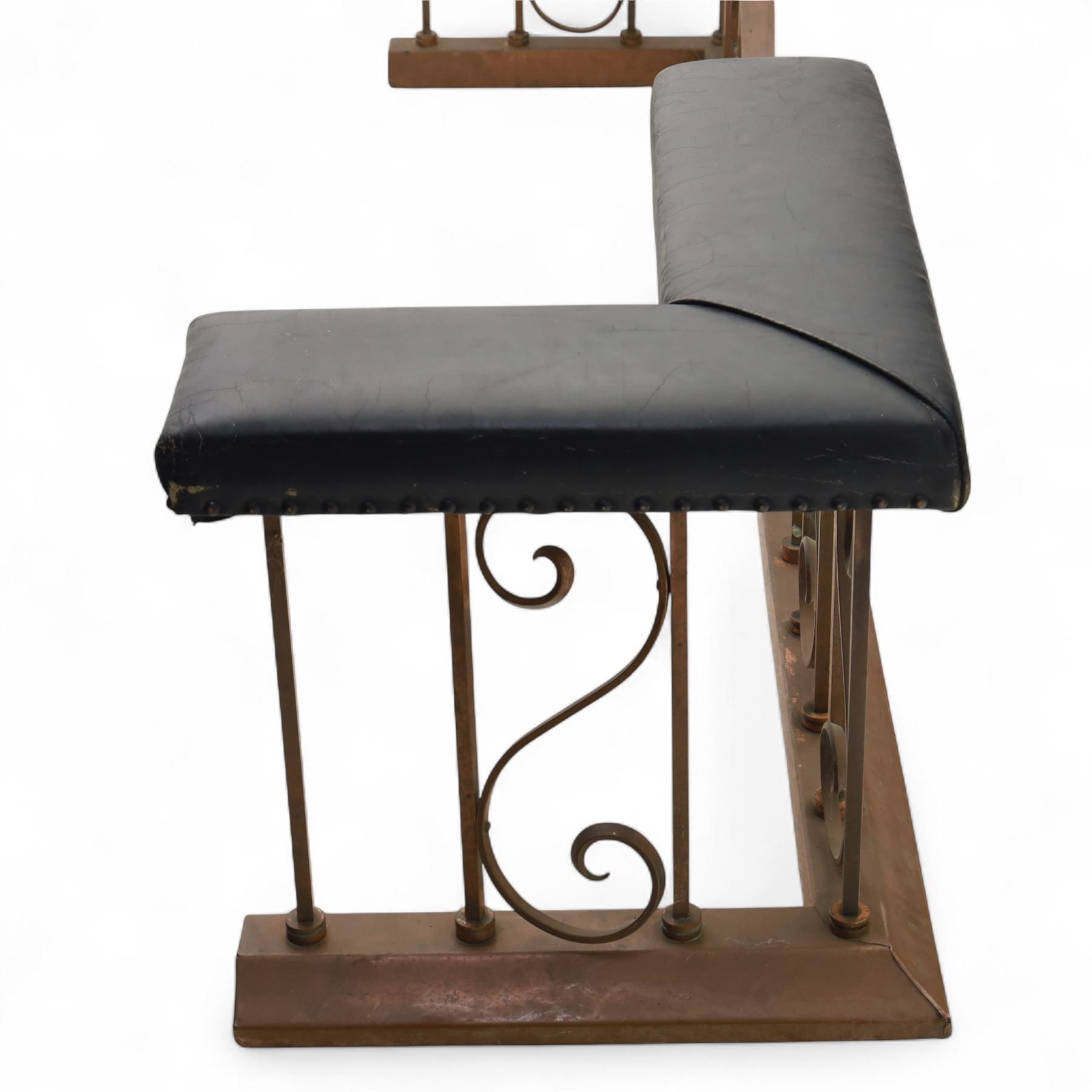 Early 20th-century Arts & Crafts copper club fender, of long serpentine form, scrolling uprights and a shaped centre support, the top rail fitted with four upholstered padded seat sections, raised on a stepped plinth base, inner dimensions 192x43cm 