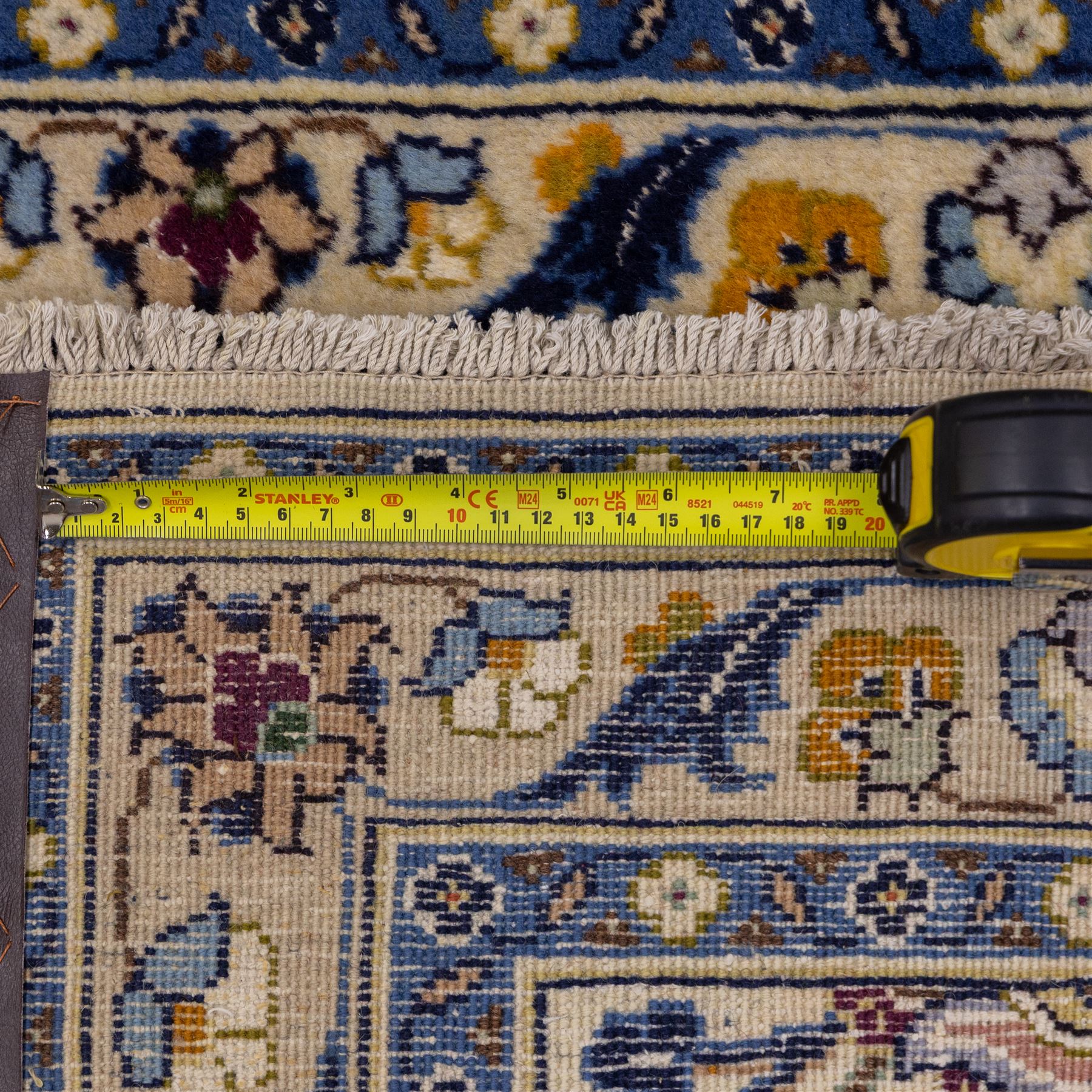 Central Persian Kashan hand-knotted runner, ivory field decorated with an elegant all-over scrolling vine design composed of finely drawn palmettes, floral strays and arabesques in a continuous lattice, principal border on an indigo ground decorated with palmette and vine scroll, flanked by multiple narrow guard stripes, with cotton fringe ends 