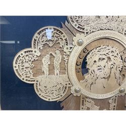 Cork carving of a religious cross depicting intricate scenes of various religious figures and motifs amongst trees and foliage, with central circular panel of Jesus Christ, in glazed frame, H95cm