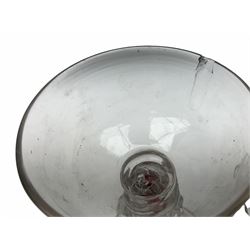 An unusual Continental drinking glass, probably 18th century, naively modelled with short round bowl upon a  twist stem with internal red cane, and prunt type decoration, upon wide spreading circular folded foot, H23cm, together with a small 19th century English glass vase, of wrythen form, H12cm.