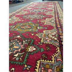 Persian red ground rug, repeating patterned spine in multicolour fashion, floral inner boarder geometric shaped outer 