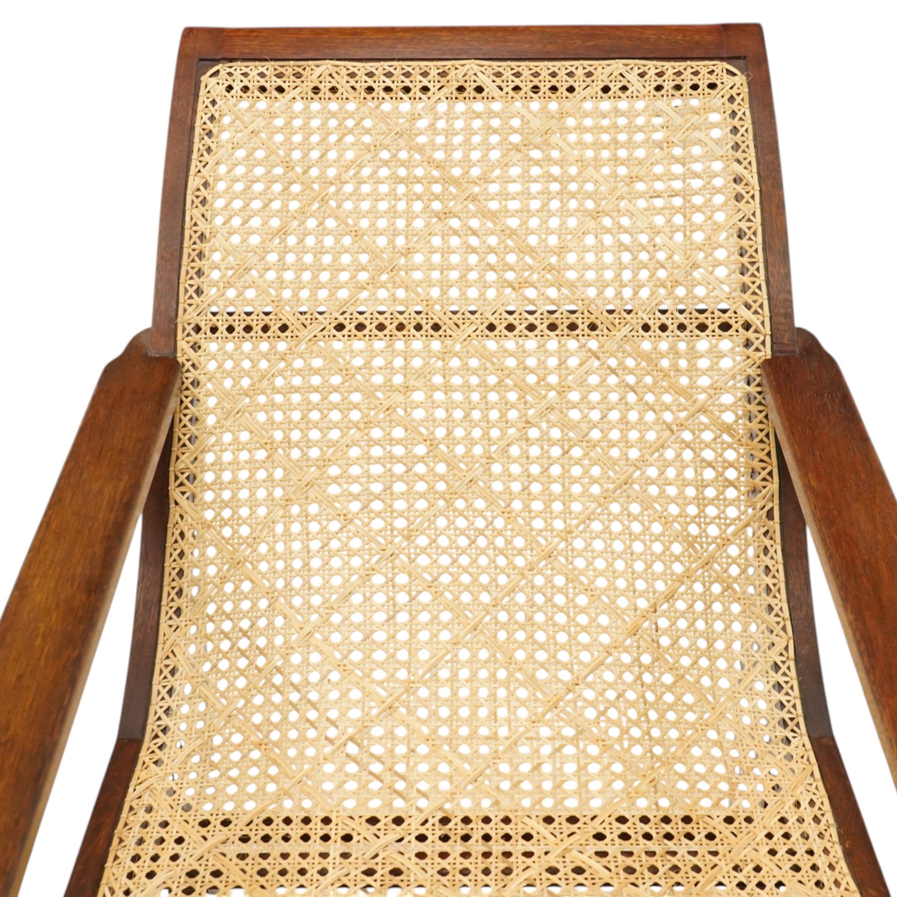 20th century teak framed plantation chair, plain cresting rail over cane back and seat, fitted with hinged extending leg rests, raised on turned front-supports united by ring-turned stretcher