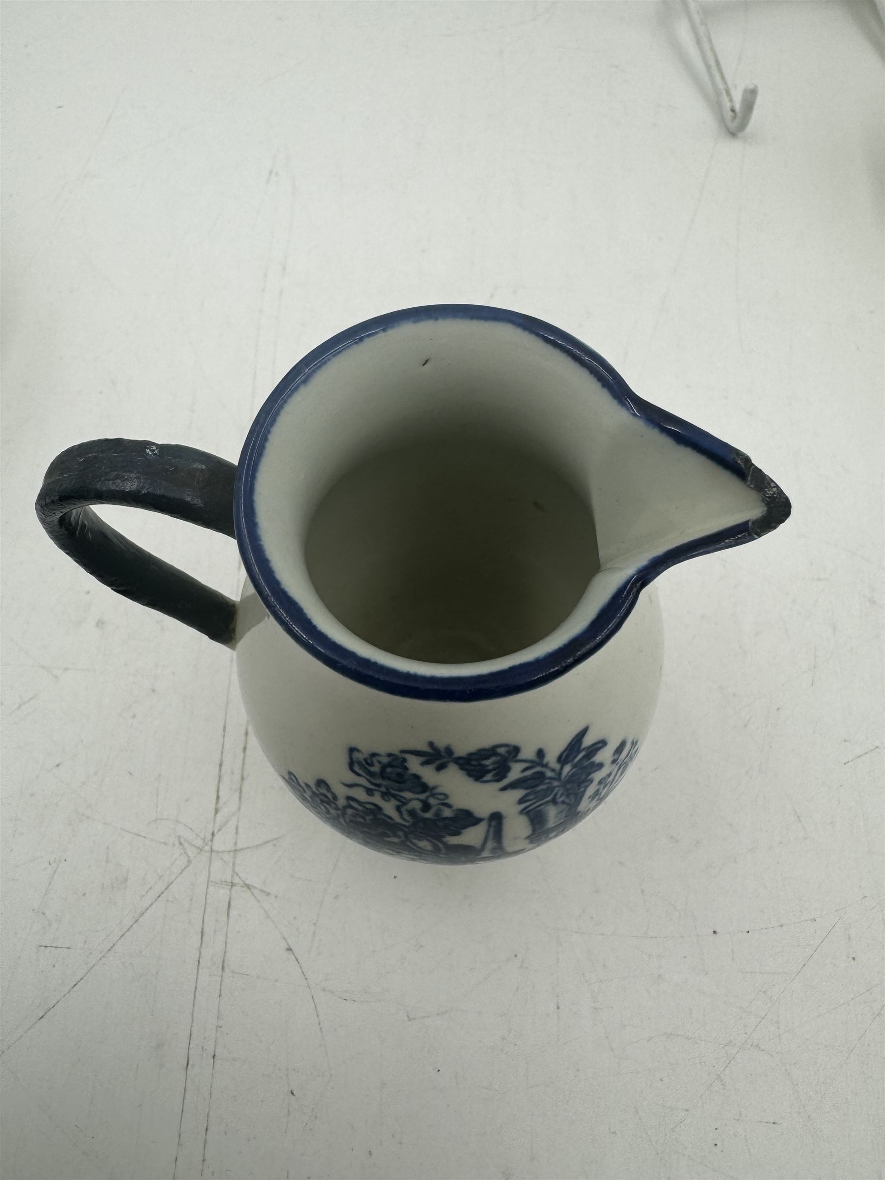 18th century Caughley blue and white sparrow jug, decorated in the Mother and Child pattern, circa 1780-1790, with underglaze C mark beneath, H9cm, together with a Worcester coffee cup, circa 1785 painted with floral sprays in underglaze blue and gilt, with crescent mark beneath, and a Caughley trio of tea cup, tea bowl and saucer, each of moulded wrythen fluted form and decorated with gilt and blue sprigs and bands, each with crescent mark beneath, (5)