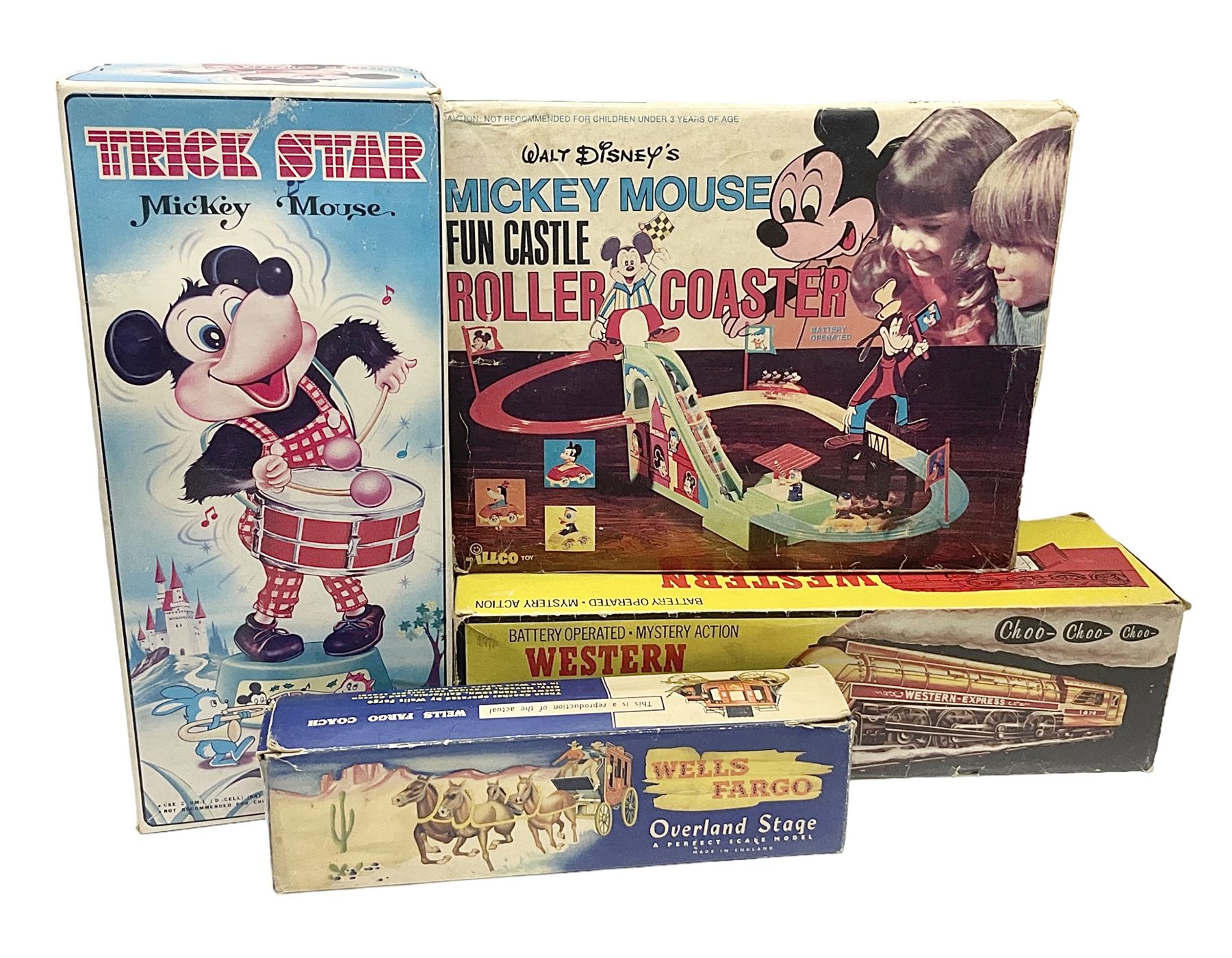 Mickey Mouse Trick Star battery operated drummer figure; Illco Mickey Mouse battery operated Fun Castle Roller Coaster; battery operated Western Express Locomotive; and JK Wells Fargo Overland Stage scale model; all boxed (4)