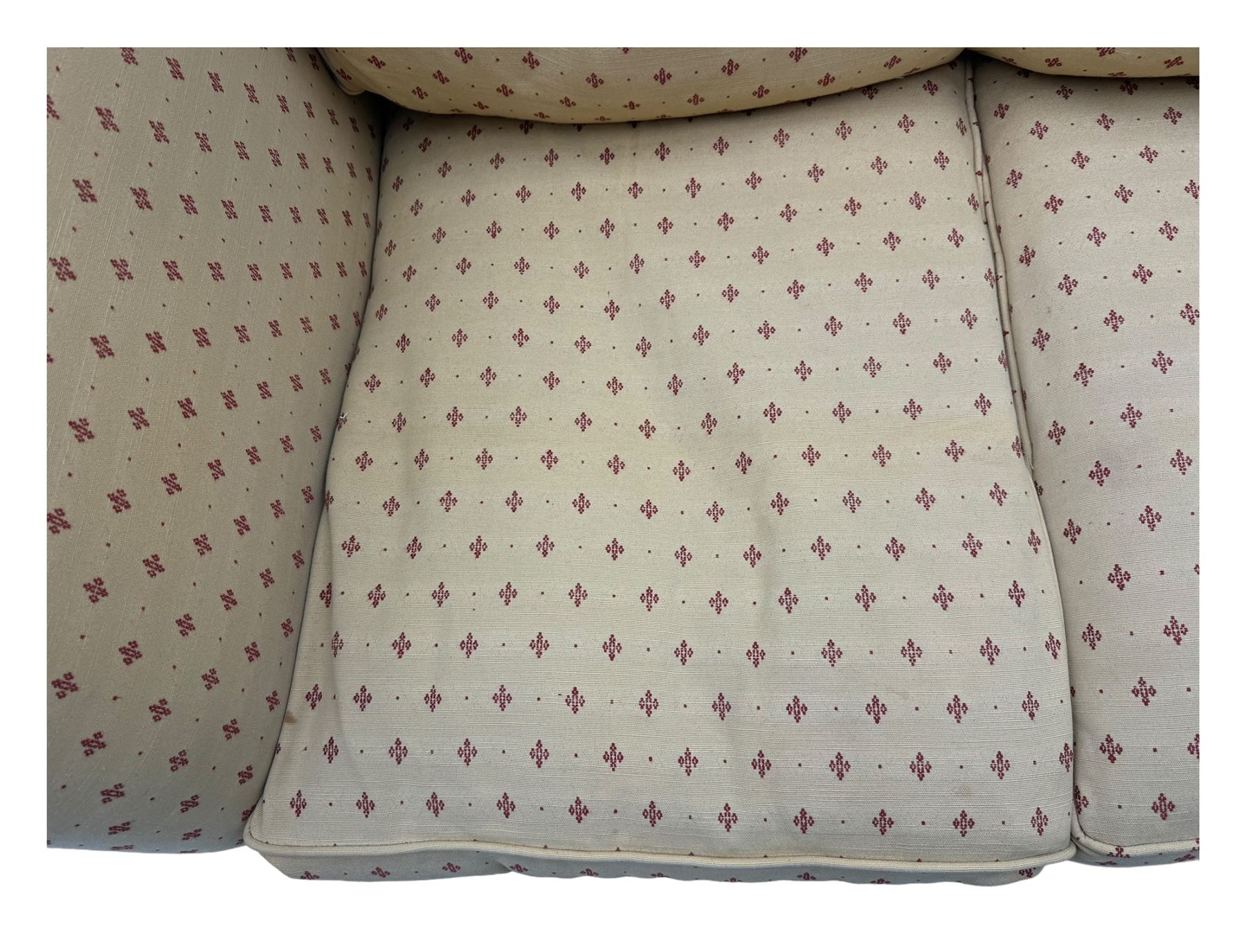 20th century Knole design two seat sofa, high back and double drop-arm joined by mahogany finials and ties, upholstered in camel ground fabric with red lozenge design, on turned supports with brass castors