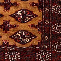 North East Persian Turkoman hand-knotted rug, camel brown field decorated with repeating rows of octagonal guls, interspersed with small geometric motifs enclosed within narrow guard borders in a palette of madder red, brown, and ivory, with cotton fringe ends  